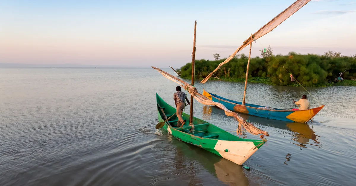 Luo fishermen casting their nets on Lake Victoria at sunrise